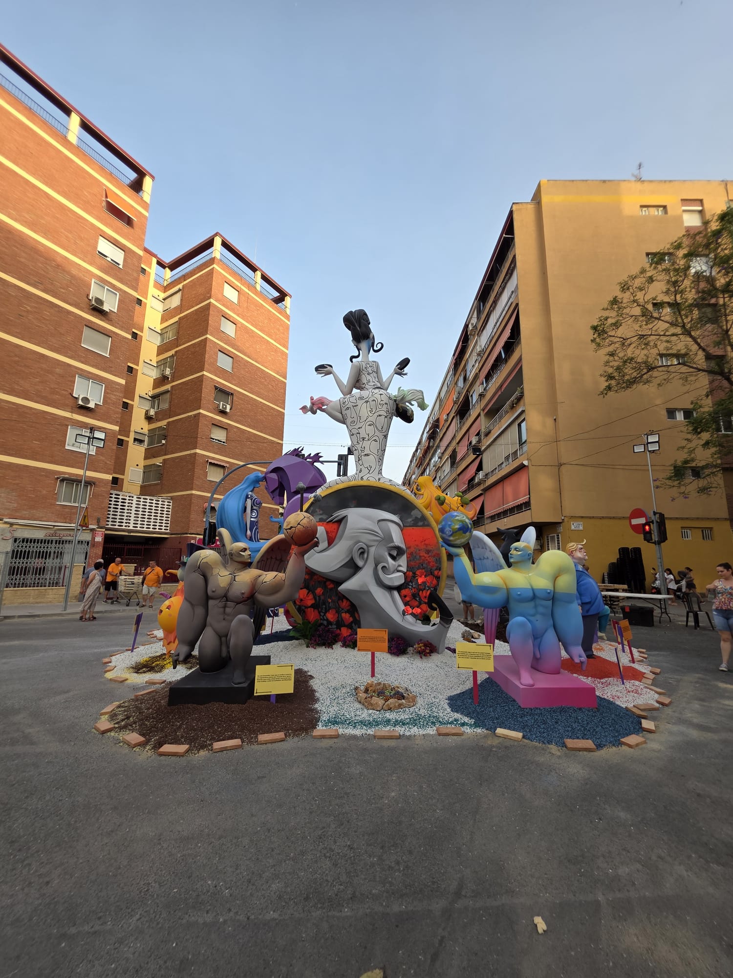 La parte trasera de la Hoguera Grande Princesa Mercedes 2026 mantiene la misma línea decorativa que el resto del proyecto, integrando piedra blanca Macael, vegetación y elementos naturales que aportan equilibrio, profundidad y continuidad visual a la ambientación.